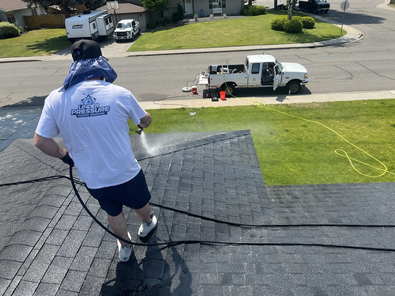 Under Pressure Power Washing team member professionally cleaning a roof